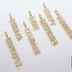 May include: A set of seven gold charm necklaces with different words spelled out in diamonds. The words are "Dream", "Love", "Happy", "Awesome", "Courage", "Grateful", and "Peace".