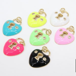 May include: Seven heart-shaped lock charms with a keyhole in the center. The charms are made of gold-tone metal and are decorated with colorful enamel and clear rhinestones. The colors of the charms are: turquoise, yellow, white, pink, green, pink, and black.
