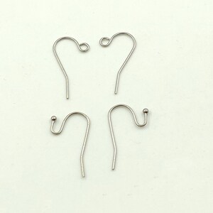 May include: Four silver earring hooks, two with a small ball at the end and two with a loop at the end.