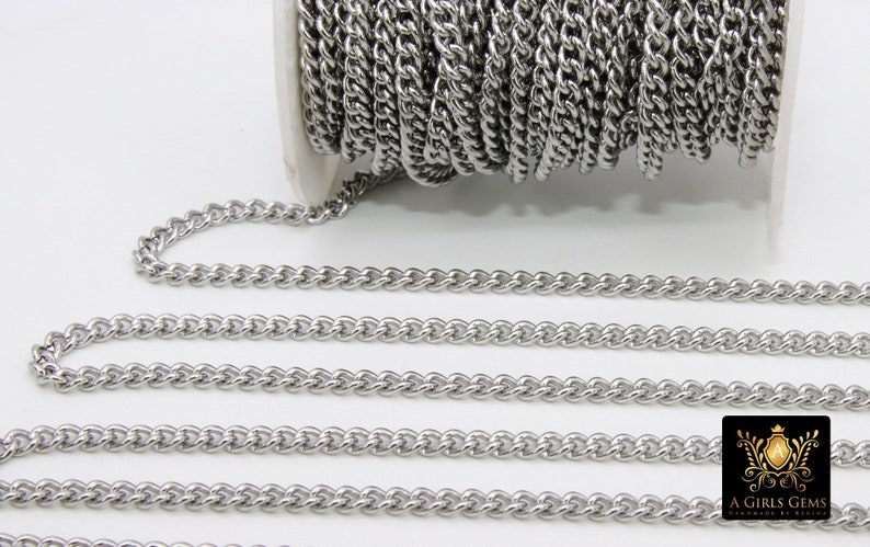 May include: A roll of silver-toned metal chain, with a portion of the chain unrolled to show the detail of the links. The chain is a curb style with a twisted design.