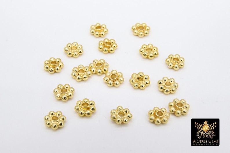 Pu&ograve; includere: Una collezione di 18 distanziatori per perline in metallo dorato con un design a forma di fiore. Ogni distanziatore ha un piccolo foro al centro.