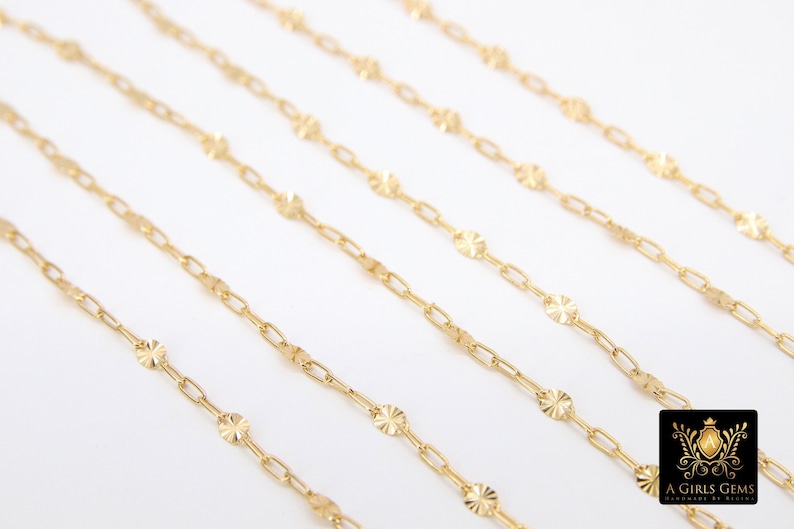 May include: Five gold chains with a delicate, patterned design. Each chain features small, round links with a textured surface.