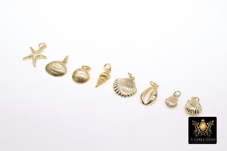 May include: A set of nine gold-coloured charms featuring various seashell designs, including a starfish, a conch shell, and a clam shell.
