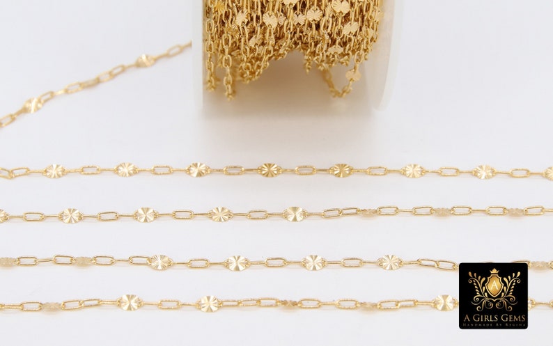 May include: Gold chain with a delicate, patterned design. The chain is made of small, oval-shaped links with a textured surface. The chain is shown in a close-up view, with several strands of the chain laid out in a straight line.