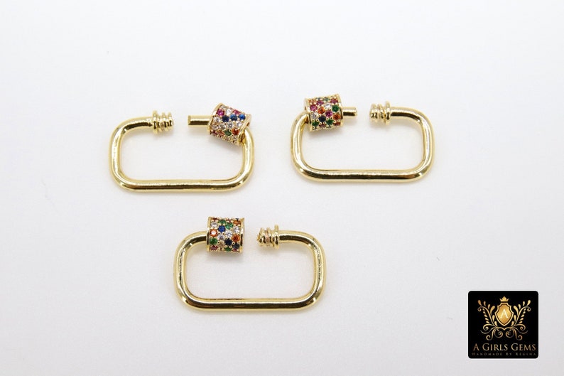 May include: Three gold-toned metal clasps with a colorful, multi-faceted stone design. Each clasp has a rectangular shape with a rounded edge and a small, round, decorative piece on one side.