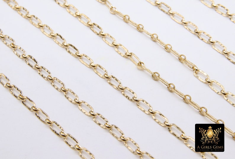 May include: Five gold chains of different lengths, all featuring a textured, oval-link design. The chains are arranged in a staggered pattern on a white background.