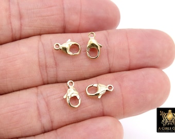 May include: Four gold-toned lobster claw clasps, commonly used for jewelry making.