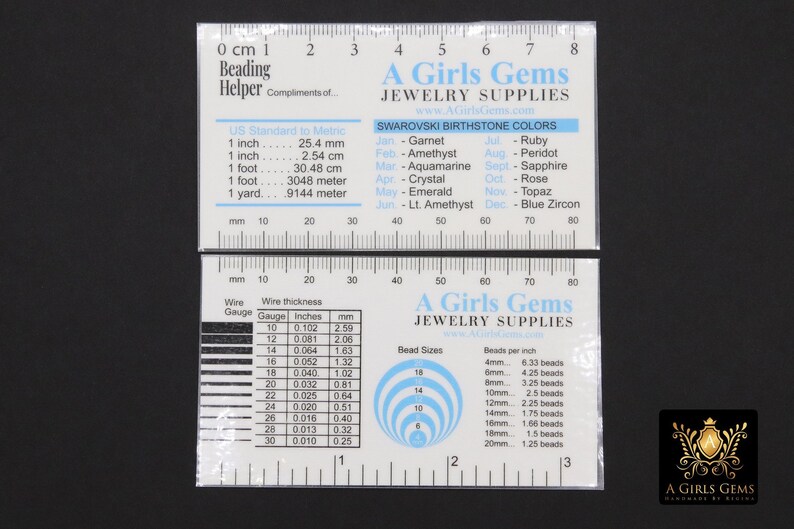 May include: A white plastic ruler with a black and white chart for bead sizes and wire gauge. The ruler has a black and white chart with the text "A Girls Gems Jewellery Supplies" and a chart of Swarovski birthstone colours.