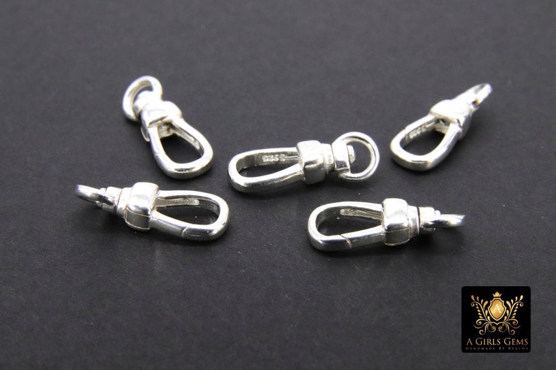 May include: Five silver-toned metal clasps or swivel hooks. The clasps are oval-shaped with a small loop at the top.