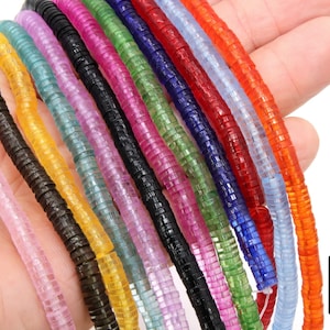 May include: Assortment of 12 strands of faceted glass beads in various colors, including pink, yellow, blue, green, and red. The beads are stacked on top of each other, creating a rainbow effect.