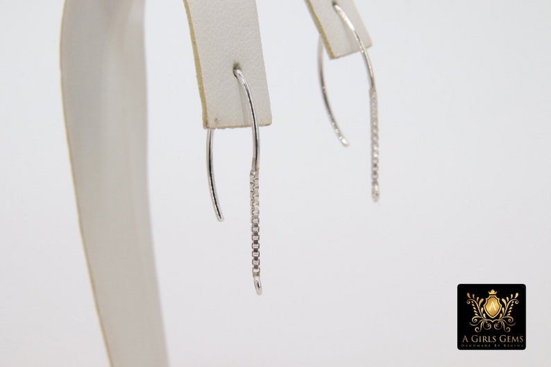 Pu&ograve; includere: Un paio di orecchini pendenti in argento con un delicato design a catena.