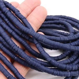 May include: A strand of dark blue polymer clay beads, each bead is a flat disc with a hole in the center. The beads are stacked on top of each other, creating a thick rope-like appearance.