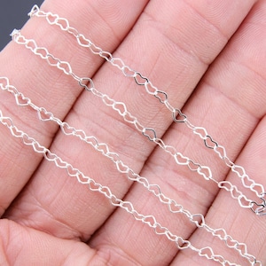 May include: Silver heart-shaped chain, a delicate and intricate design, perfect for jewelry making or crafting projects.