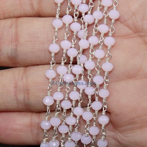 May include: A strand of light purple faceted glass beads strung on a silver chain. The beads are approximately 4mm in diameter and the chain is delicate and has a simple design.