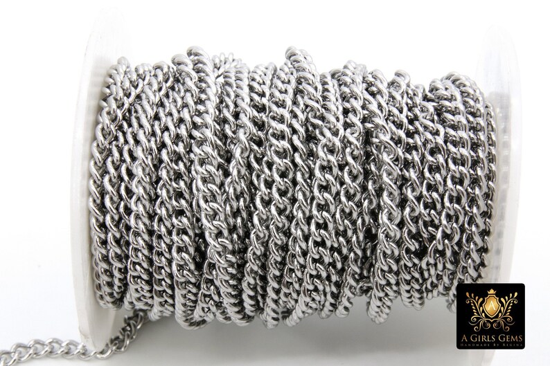 May include: A silver metal chain is wound around a spool. The chain is a twisted curb style.
