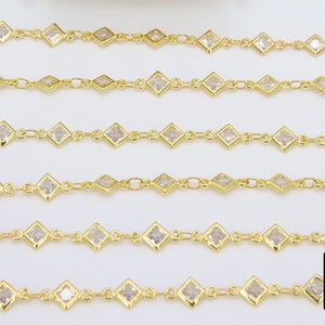 K&ouml;nnte beinhalten: F&uuml;nf Str&auml;nge goldener Kette mit quadratischen, klaren Steinen. Die Kette besteht aus kleinen, miteinander verbundenen Metallteilen.