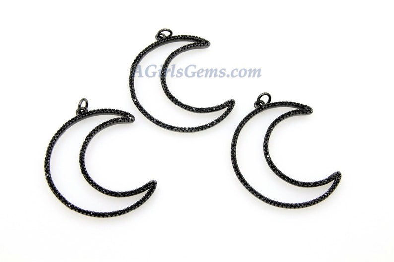 Pu&ograve; includere: Tre ciondoli a forma di mezzaluna in metallo nero con accenti di cristallo nero. Ogni ciondolo ha un anello nella parte superiore per essere attaccato a gioielli.