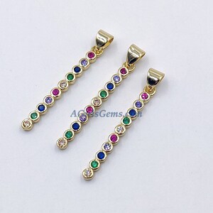 May include: Three gold pendants with a line of colorful round stones. Each pendant has a different color order of stones, including blue, green, red, purple, and clear.
