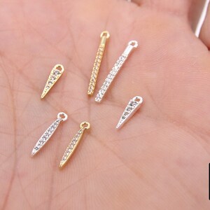 Könnte beinhalten: Fünf verschiedene Arten von Schmuck-Findings mit klaren Strasssteinen. Die Findings sind in Gold-, Silber- und Rhodium-Finish.