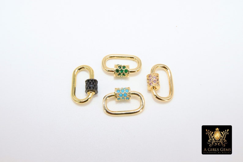 May include: Four gold-colored oval-shaped clasps with decorative center bars. One clasp has a black gem center, another has green gems, a third has turquoise gems, and the last has pink gems. The clasps are on a white background.