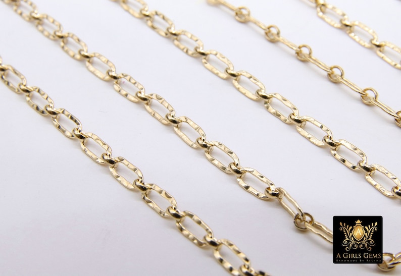 May include: Four gold chains of different lengths, all featuring a textured oval link design. The chains are arranged in a staggered pattern on a white background.