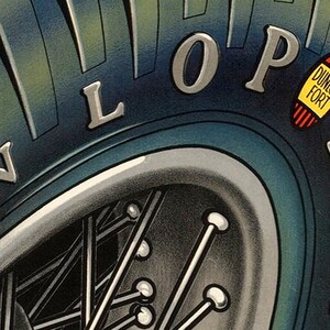 May include: Close-up of a blue tire with the word "DUNLOP FORT" in white lettering on a yellow oval sticker. The tire also has the word "DUNLOP" in silver lettering on the side.