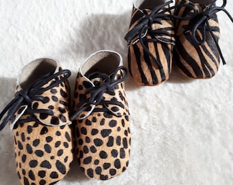 Baby shoes made of animal printed leather.