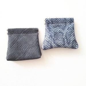 Petit porte-monnaie en cuir imprimé unique. Une pochette en cuir avec un cadre compressible.