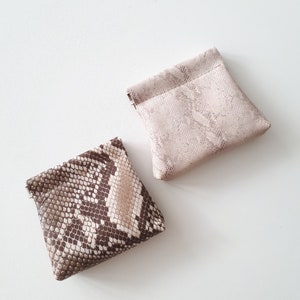 Cartera de monedas de cuero pequeña hecha de cuero estampado único. Una bolsa de cuero con marco exprimido.