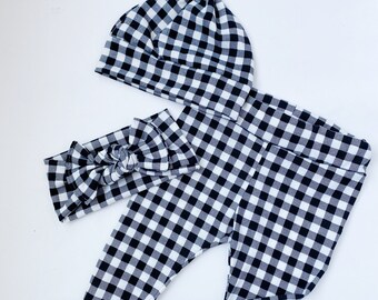 May include: Black and white checkered baby pants, headband, and knotted hat.