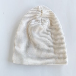 May include: A white waffle knit beanie hat.