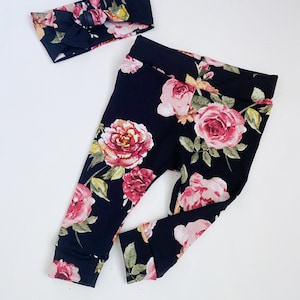 May include: A black floral leggings and headband set with a pink and red floral pattern.
