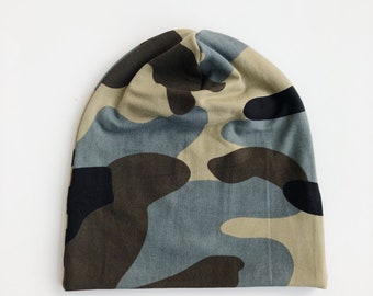 May include: A camouflage beanie hat in shades of green, brown, black, and tan. The hat is made of a soft fabric and is designed to fit snugly on the head. The hat is a stylish accessory for any casual outfit.