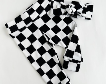 May include: Black and white checkered leggings with a matching headband. The leggings have a cuffed bottom and the headband is tied in a bow.