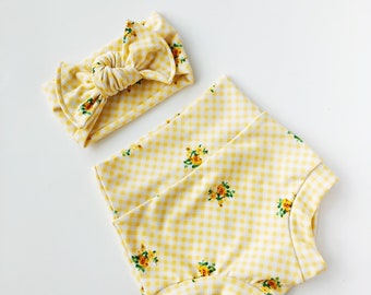 May include: A yellow and white gingham headband with a floral print and a matching gingham and floral print baby bloomer.