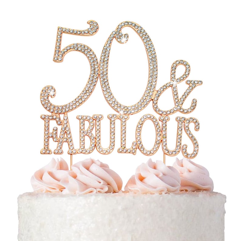 May include: Gold cake topper with rhinestones that says "50 & Fabulous".