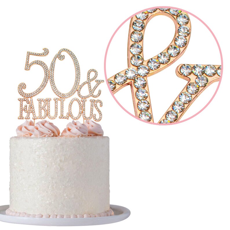 May include: Gold cake topper with rhinestones that says "50 & Fabulous".