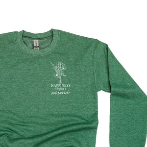 Op de afbeelding: Groen sweatshirt met een witte afbeelding van een boom en de tekst "Happiness is being a mini".
