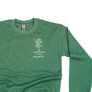 Könnte beinhalten: Grüner Pullover mit einem weißen Aufdruck eines Blumenstraußes und dem Text "Happiness is being a mimi".