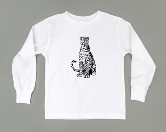 May include: White long-sleeve t-shirt with a black and white illustration of a leopard sitting on the front. The text "LITTLE MAMA SHIRT SHOP" is printed in black at the bottom of the shirt.