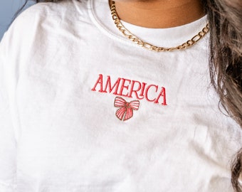 Geborduurd Comfort Colors T-shirt - Girly America met strik (midden) | 4 juli-outfit | Onafhankelijkheidsdag-shirt | Patriottisch T-shirt met print |