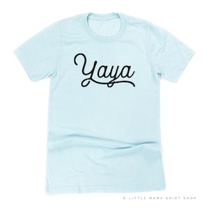 Puede incluir: Una camiseta azul claro con la palabra "Yaya" escrita en una fuente cursiva negra.