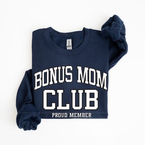 May include: A navy blue sweatshirt with white text that reads "Bonus Mom Club Proud Member".