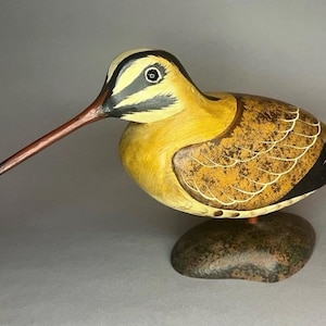 May include: A white ceramic mug with a black handle and the text "But First, Coffee" in a handwritten style. The mug is on a white surface. The mug is approximately 4 inches tall.