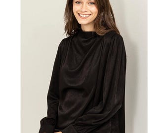 May include: A black mock neck blouse with long sleeves and a slightly gathered neckline.