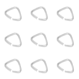 Puede incluir: Nueve pendientes de aro de plata en forma de triángulo. Los aros están abiertos y tienen un espacio en un lado.