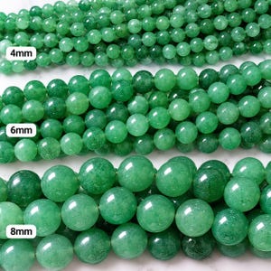 Op de afbeelding: Drie strengen gladde, ronde groene aventurijn kralen horizontaal gerangschikt. De bovenste streng bevat 4mm kralen, de middelste streng 6mm kralen en de onderste streng 8mm kralen. Elke streng is voorzien van een label met de maat.