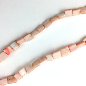 May include: A strand of square-shaped shell beads in shades of pink and white.