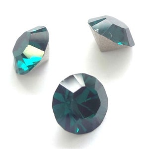 Pode incluir: Três pedras preciosas facetadas, de cor verde-azulado, são exibidas sobre um fundo branco. As pedras têm um corte brilhante, refletindo a luz para criar um efeito cintilante. As pedras são provavelmente usadas para joias ou fins decorativos.