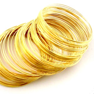 Op de afbeelding: Een stapel gouden draadringen, perfect voor het maken van sieraden of andere doe-het-zelfprojecten.